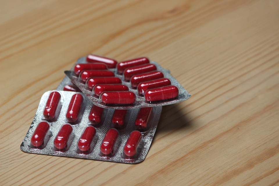 Image of packages of red pill capsules.