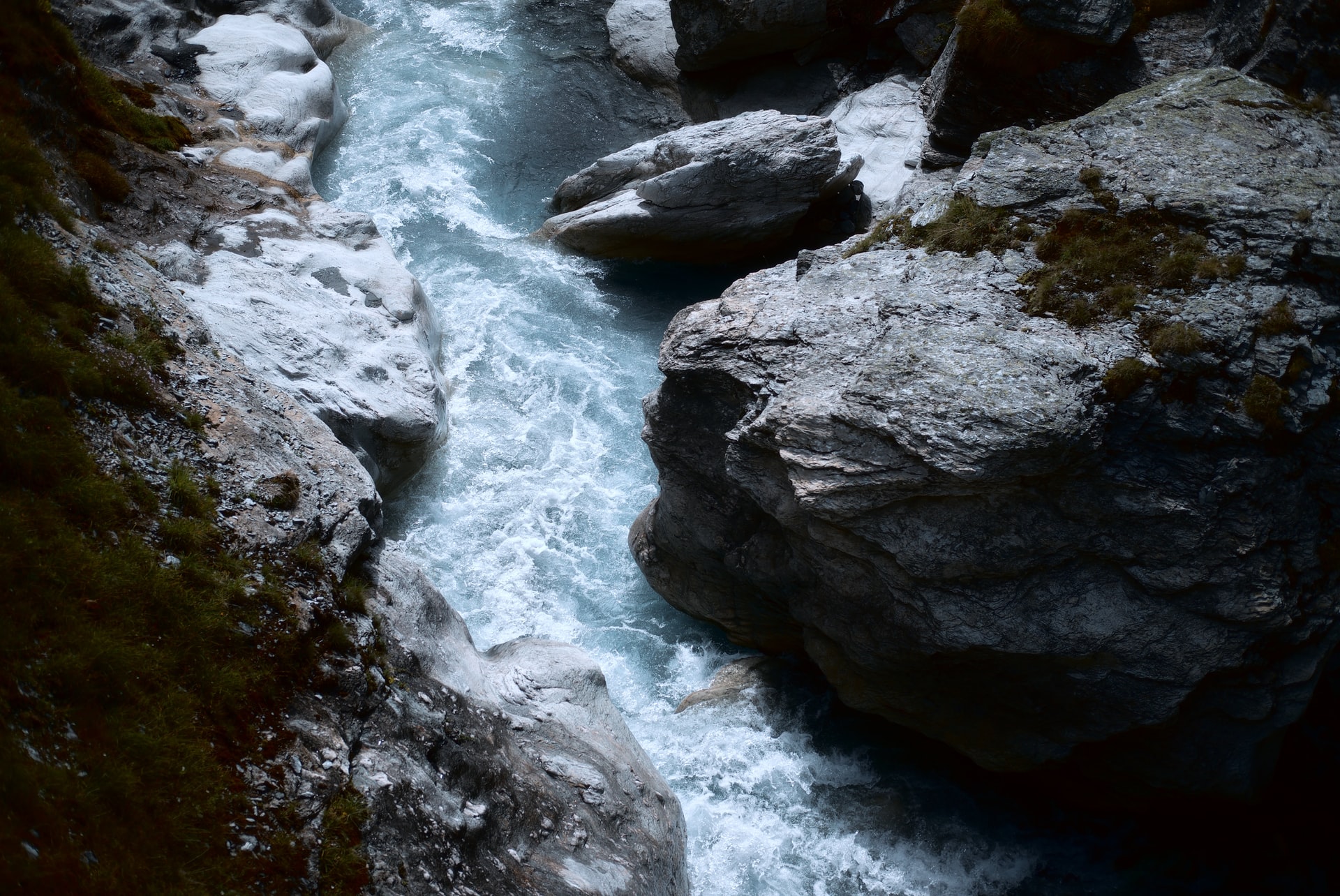 A nature scene with a rushing river flowing between rocks.
