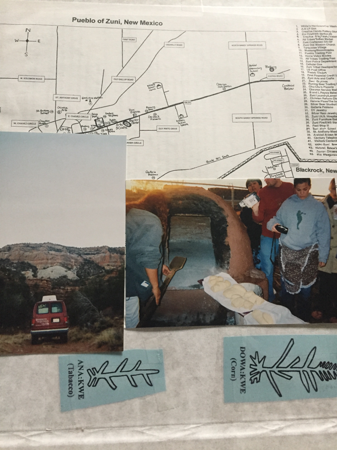 A scrapbook page contains a black and white road map of the Zuni reservation, two photographs, and two slips of blue paper with the Zuni symbols and words for "Corn" and "Tobacco." The photo on the left shows the red Washington and Jefferson College van parked near the scenic mountains surrounding the reservation. The second photo shows students shoveling bread into an outdoor clay oven. 